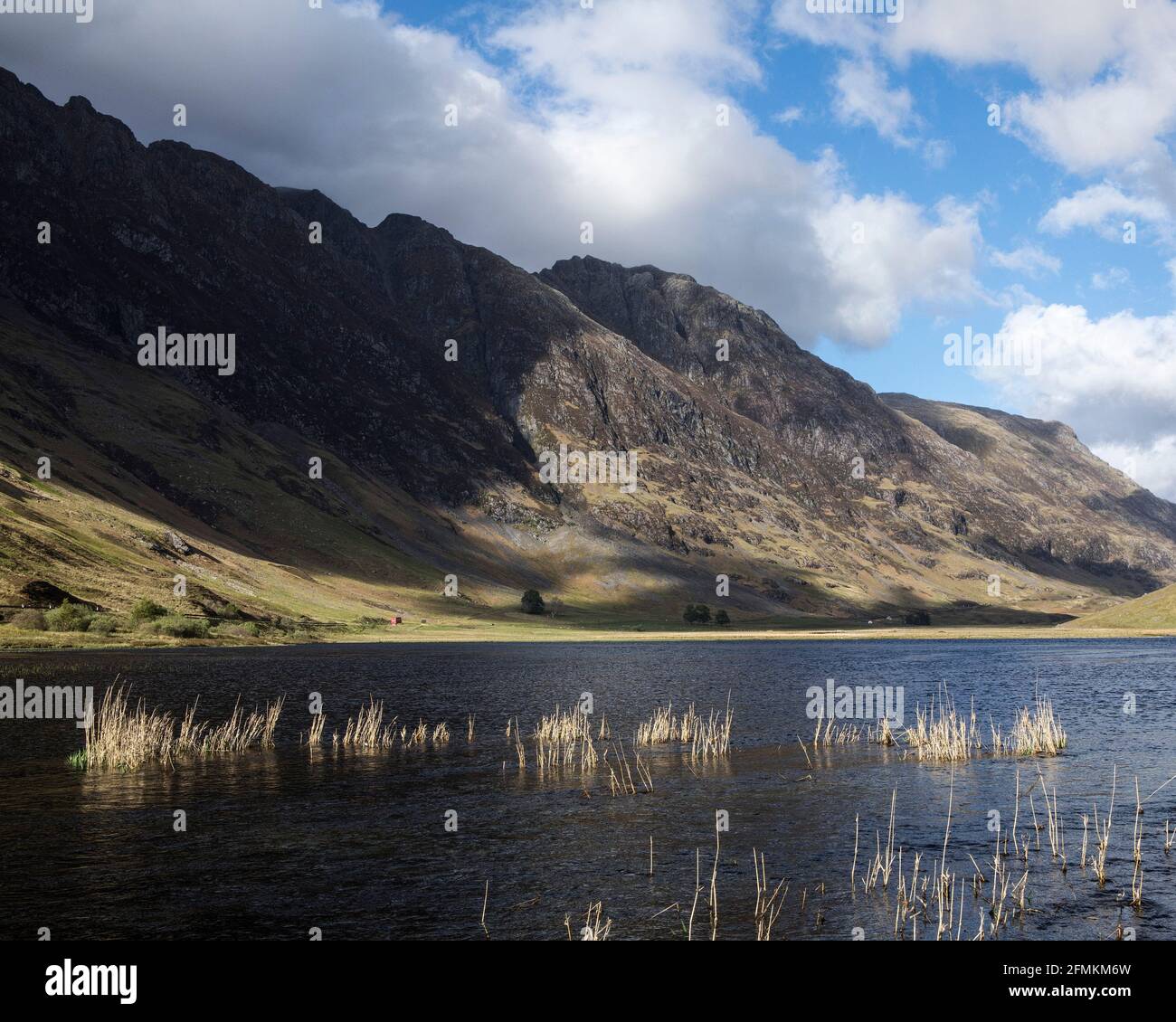 Singolo camion rosso che viaggia su una strada scozzese deserta, Glencoe, Scozia, Regno Unito Foto Stock