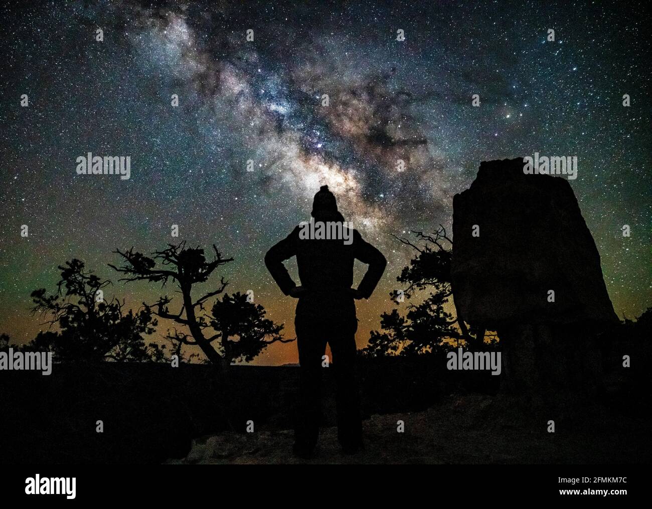 La Via Lattea che sorge sul Grand Canyon, con una persona in primo piano. Fotografato a Shoshone Point. Foto Stock