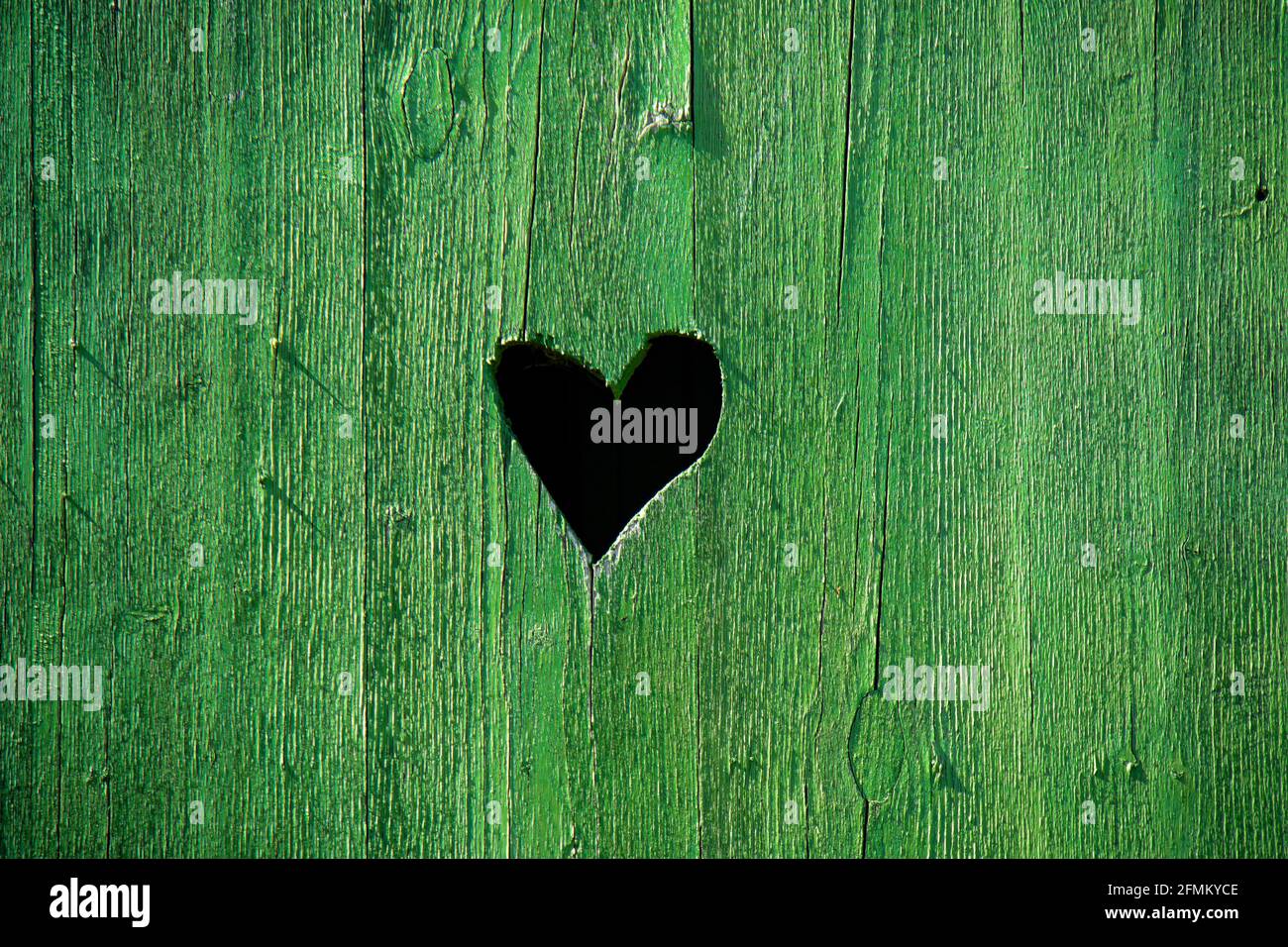 Foro a forma di cuore in una porta di legno verde Foto Stock