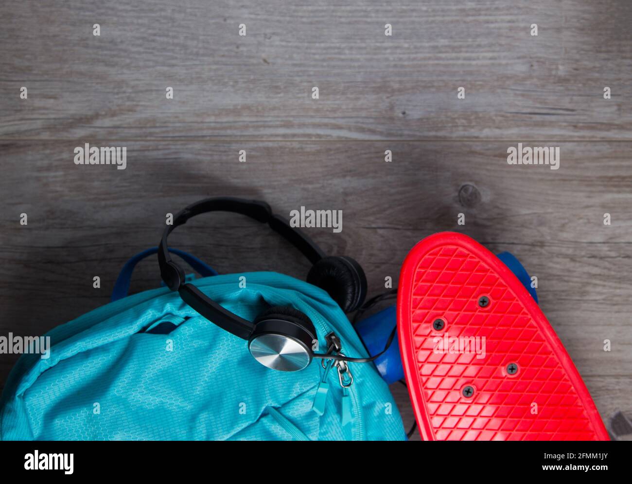 Skateboard con cuffie e una borsa - mezzi alternativi di concetto di trasporto Foto Stock