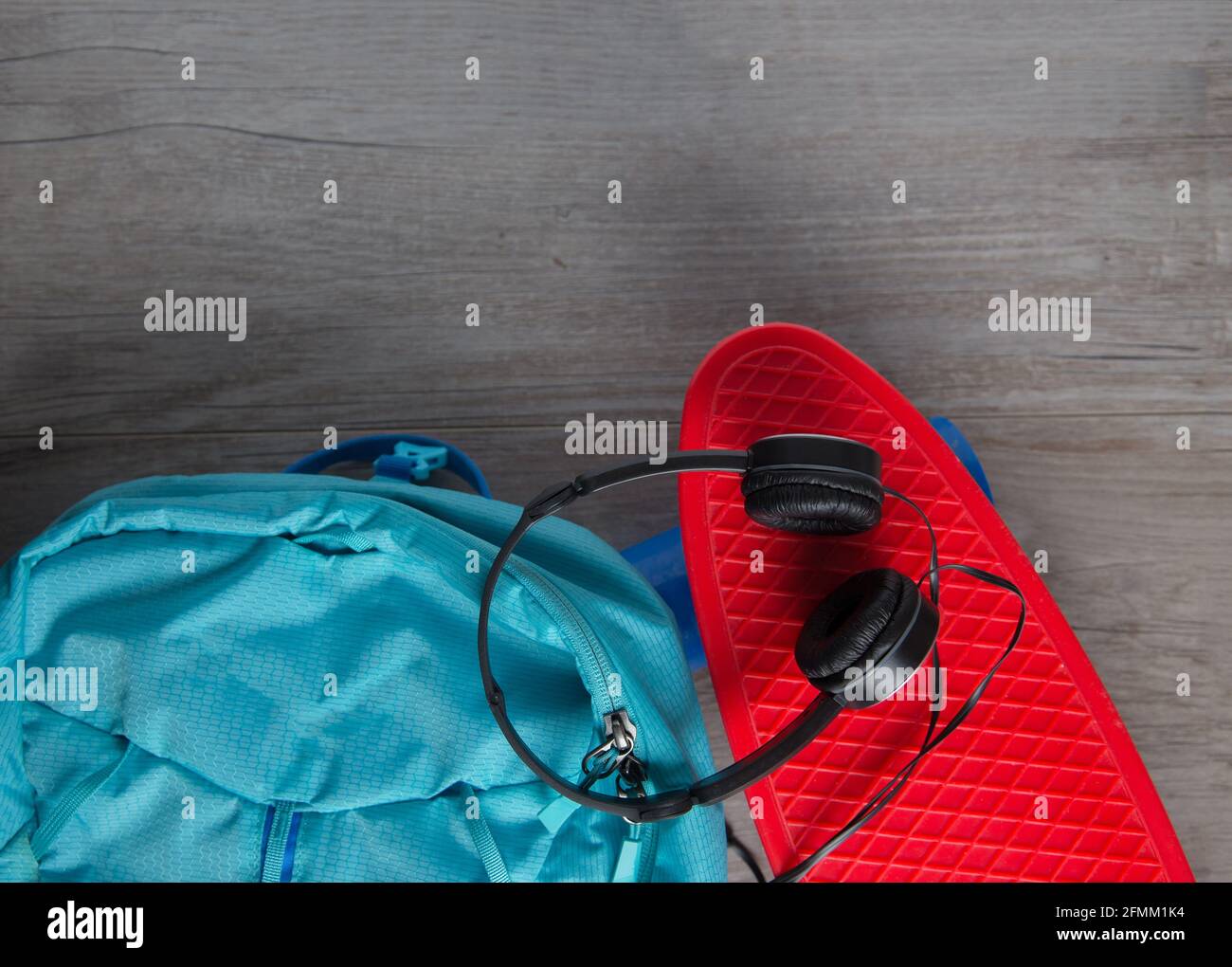 Skateboard con cuffie e una borsa - mezzi alternativi di concetto di trasporto Foto Stock