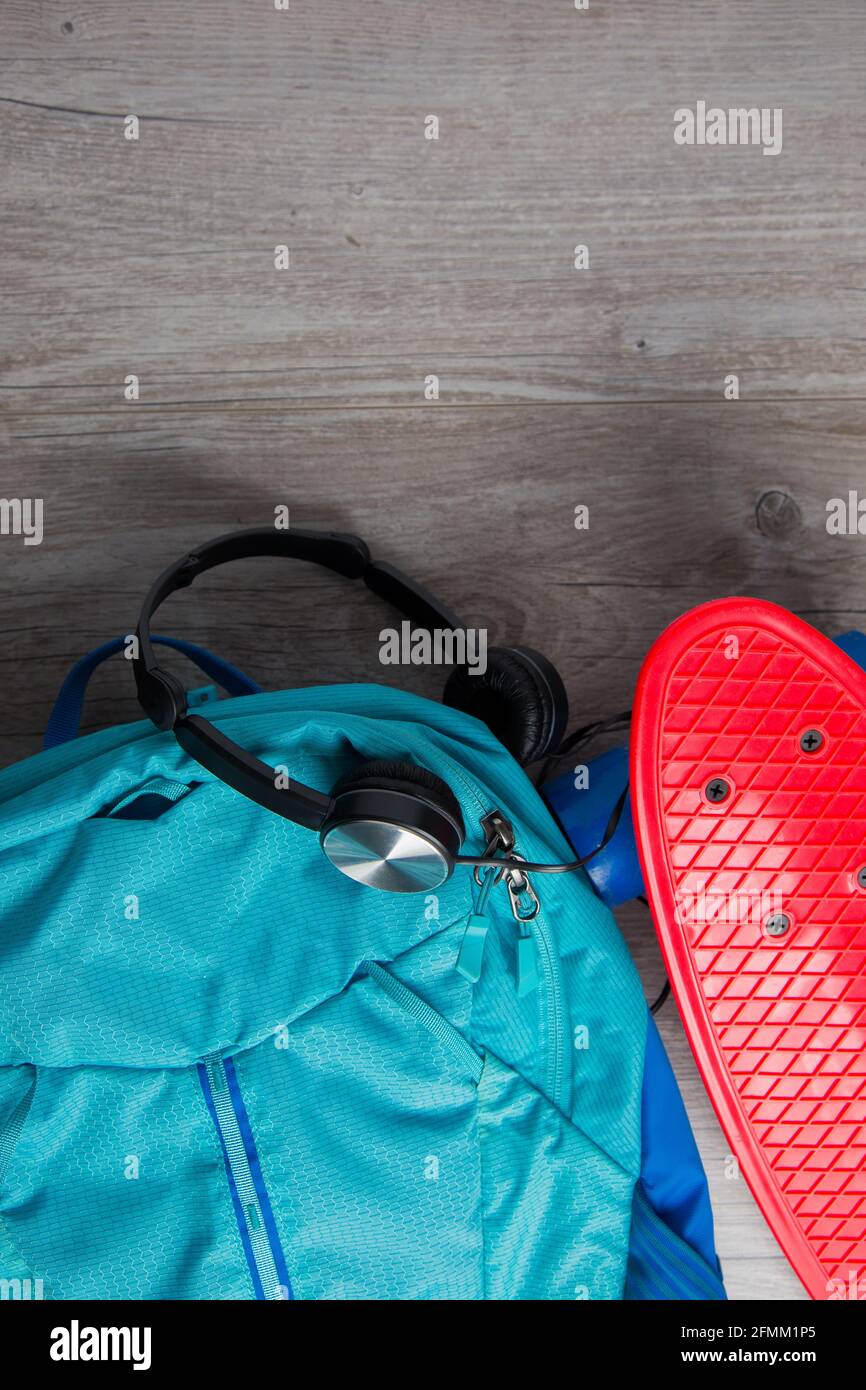 Skateboard con cuffie e una borsa - mezzi alternativi di concetto di trasporto Foto Stock