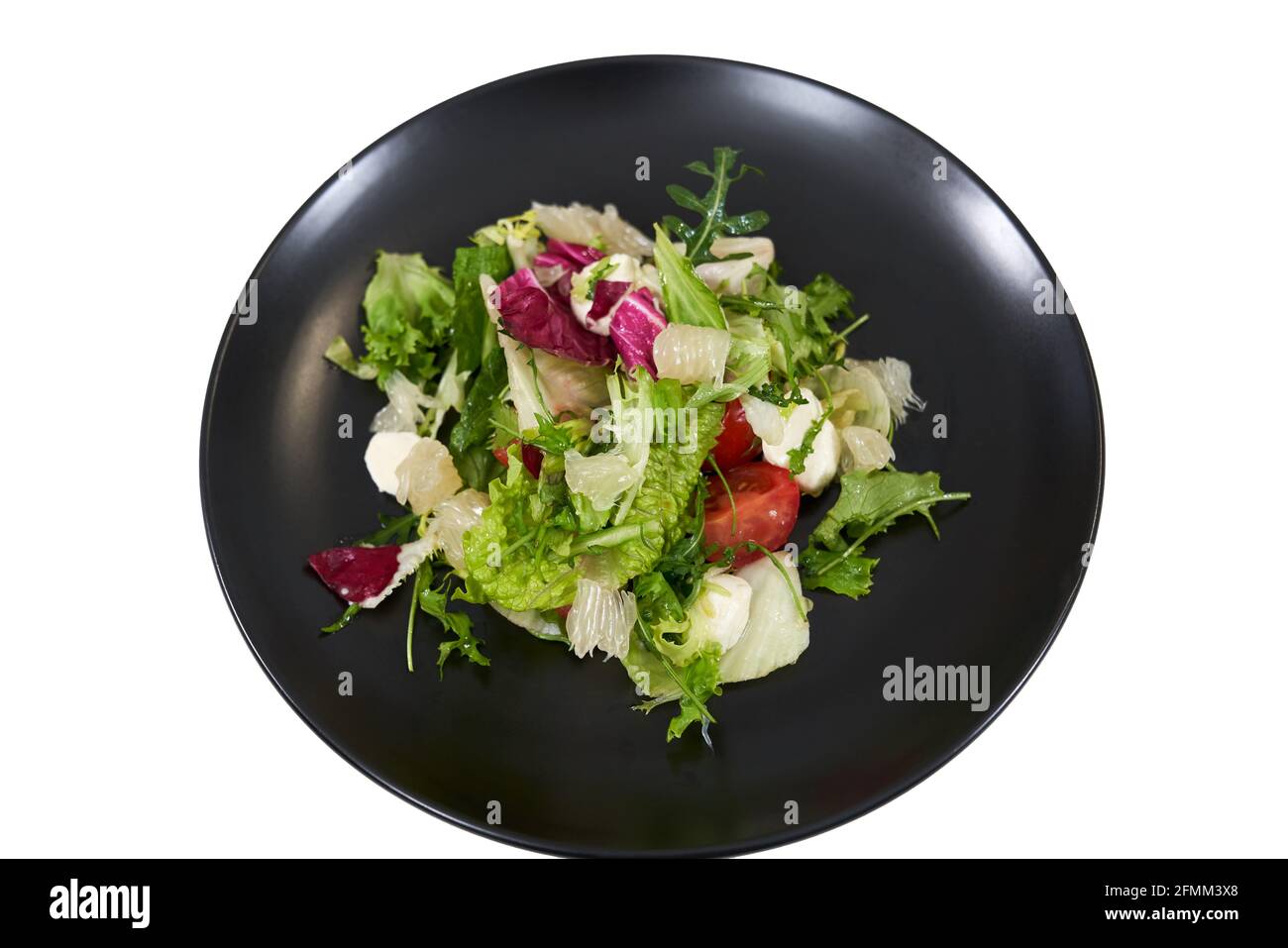 Vista dall'alto primo piano mix foglie di lattuga fresca colori diversi in nero piatto moderno su sfondo bianco. Concetto di insalata succosa con verdure fresche per mantenere il peso corporeo. Foto Stock