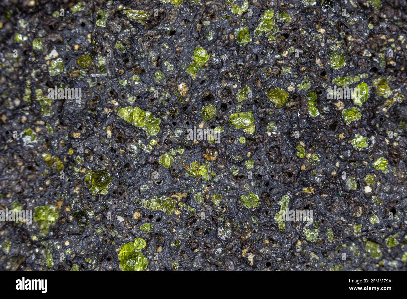 Cristalli di Peridot grezzi, ancora incorporati nella roccia vulcanica ospite. Dalle isole hawaiane. Foto Stock