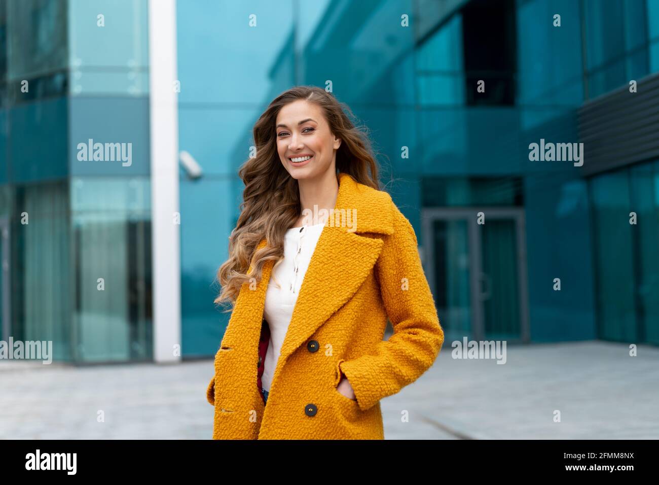 Donna di affari vestito giallo cappotto in piedi all'aperto caporativo  edificio sfondo Uomo d'affari caucasico femminile sulla strada della città  vicino alla costruzione di uffici Foto stock - Alamy