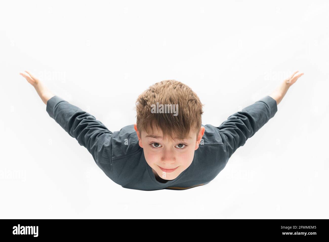 Guy vola come un aereo isolato su sfondo bianco. Concetto sognante Foto Stock