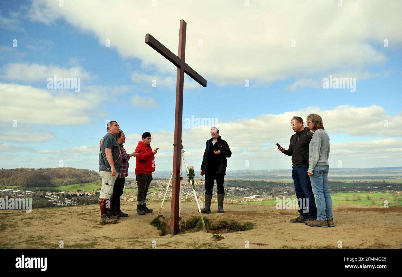 Portando una croce di legno fino Cam Peak il Venerdì Santo prima della Domenica di Pasqua in una passeggiata di testimone, Gloucestershire Foto Stock