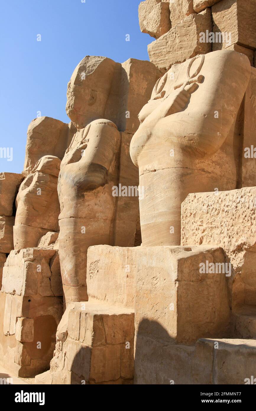 Fila di statue scolpite con cielo blu al Tempio di Karnak, Luxor, Egitto Foto Stock