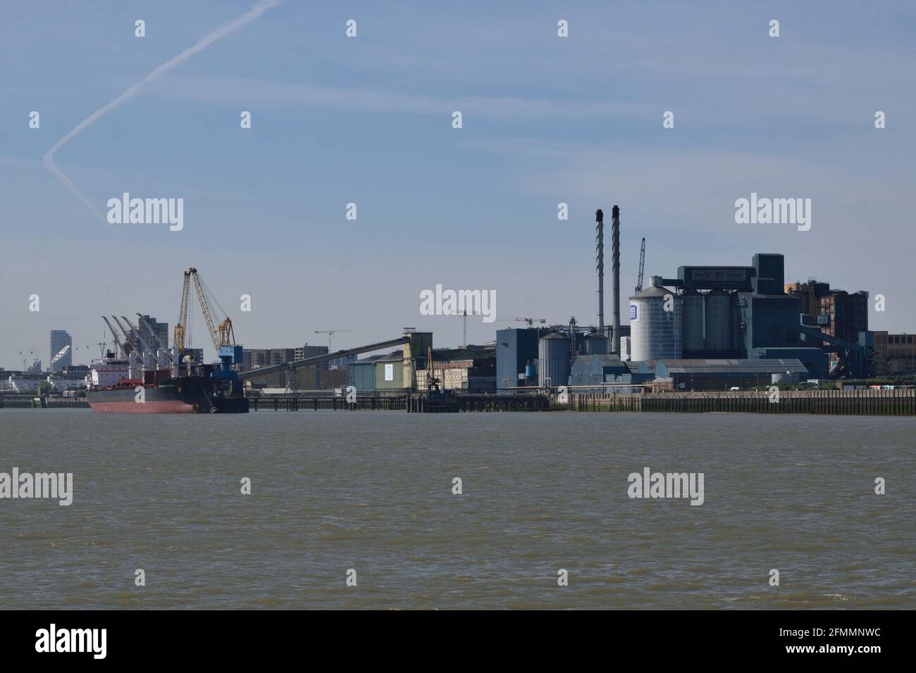 Vista dello scarico delle navi da carico presso il Thames Refinery Wharf di Tate & Lyle e la fabbrica di Silvertown, Londra, Inghilterra. Foto Stock