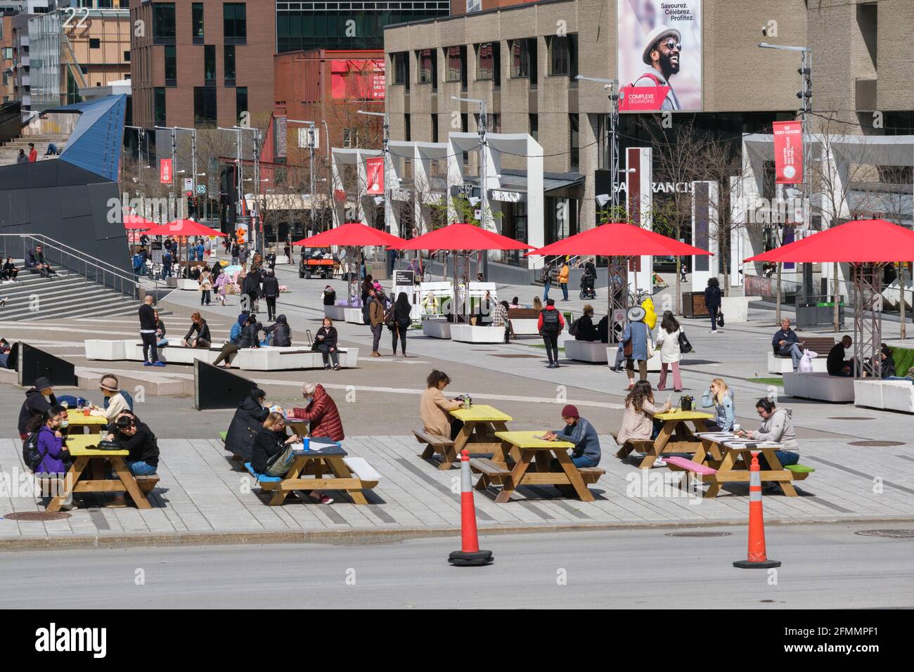 Montreal, CA - 6 maggio 2021: Persone sedute a tavoli da picnic su Ste Catherine Street nel centro di Montreal. Foto Stock