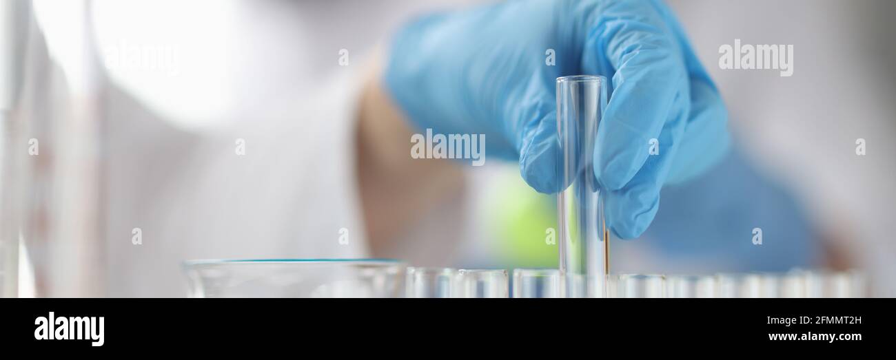 La mano guanto toglie la provetta medica Foto Stock