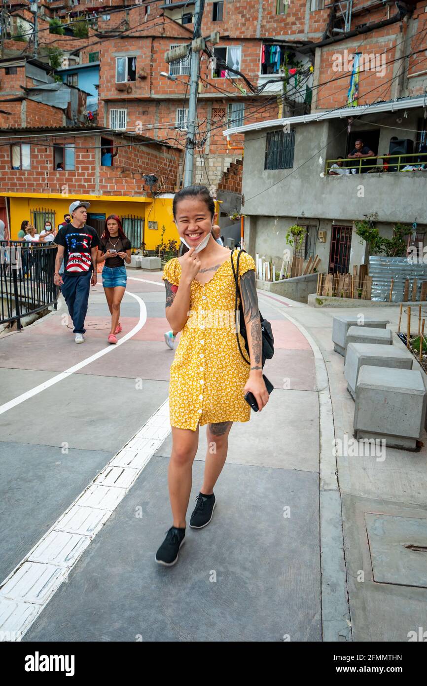 Medellin, Antioquia, Colombia - Marzo 27 2021: Giovane donna asiatica  indossa un vestito giallo e cammina nella Comuna 13, un quartiere turistico  Foto stock - Alamy