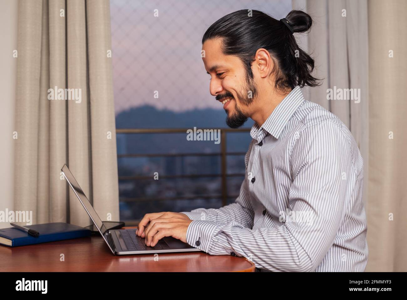 Giovane latino che lavora a casa in soggiorno Foto Stock