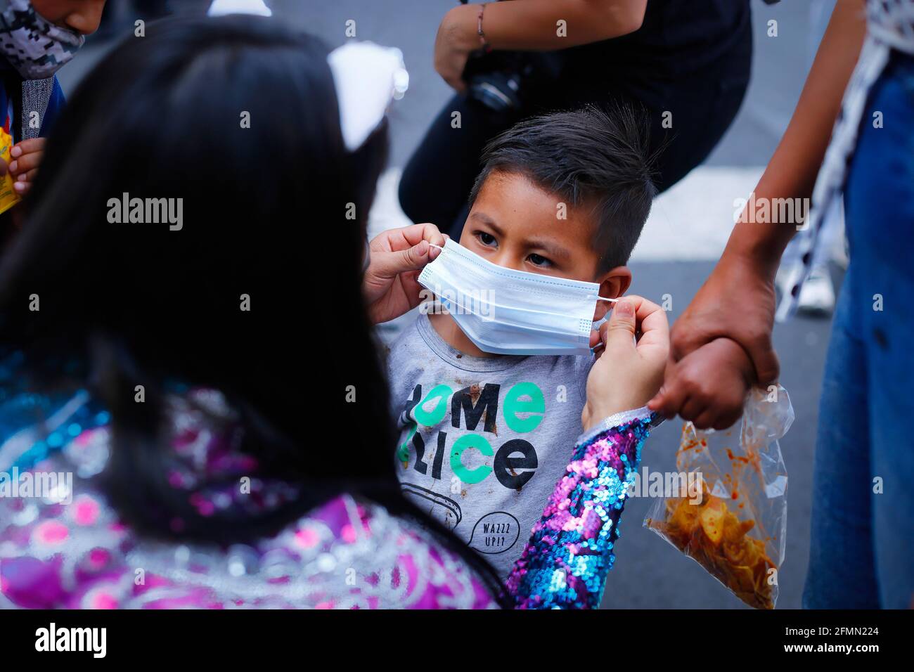 Messico, Messico. 10 maggio 2021. Un Luchador messicano aiuta un bambino a indossare una maschera facciale. 'La Brigata due delle tre cascate' chiamato dal messicano City Youth Institute ha fatto un giro di Madero Street nel centro storico incoraggiando l'uso di maschere facciali, poiché la pandemia continua ancora nonostante il semaforo epidemiologico giallo. (Foto di Guillermo Diaz/SOPA Images/Sipa USA) Credit: Sipa USA/Alamy Live News Foto Stock