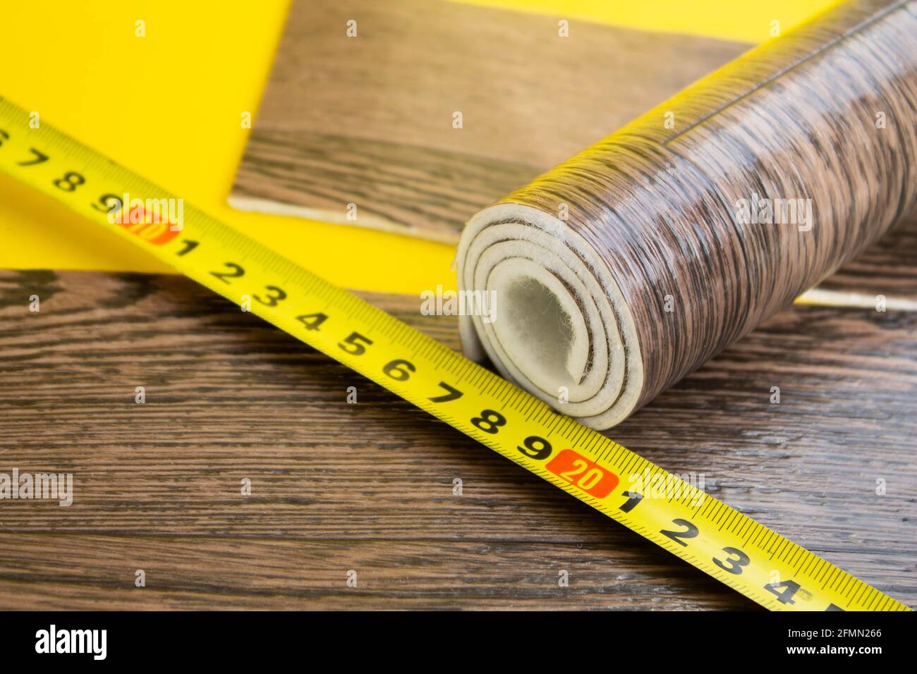 Metro a nastro in linoleum e coltello su fondo isolato. Un pezzo di linoleum. Misurazione e taglio del linoleum. Linoleum per pavimenti in PVC. Galleggiamento domestico Foto Stock