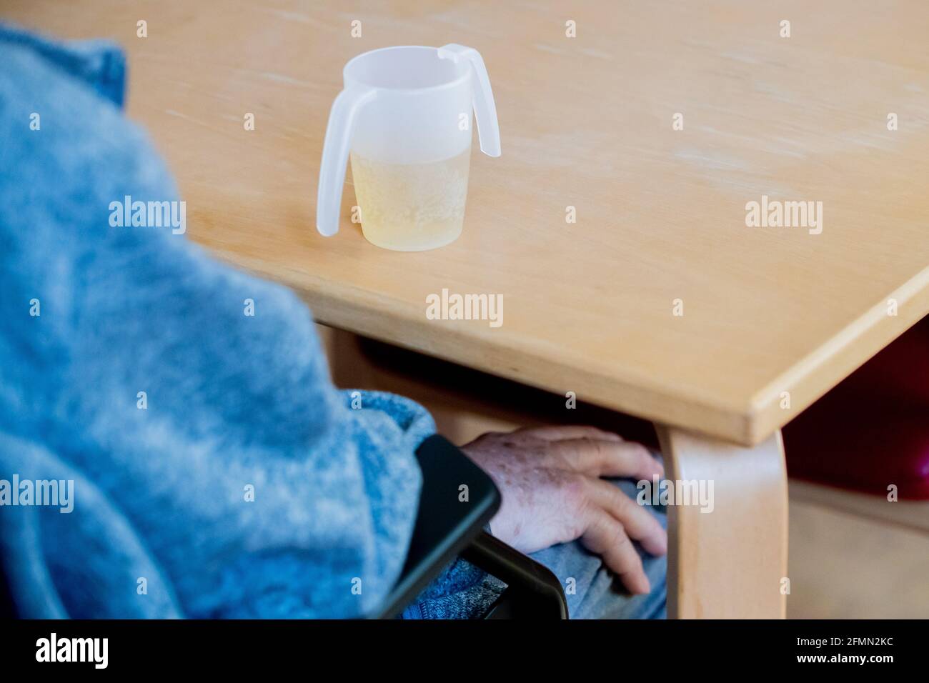 Berlino, Germania. 10 maggio 2021. Un paziente si siede di fronte a una tazza da bere nel reparto di geriatria acuta dell'ospedale di Havelhöhe. Il 12 maggio si celebra ogni anno la Giornata Internazionale della cura. Credit: Christoph Soeder/dpa/Alamy Live News Foto Stock