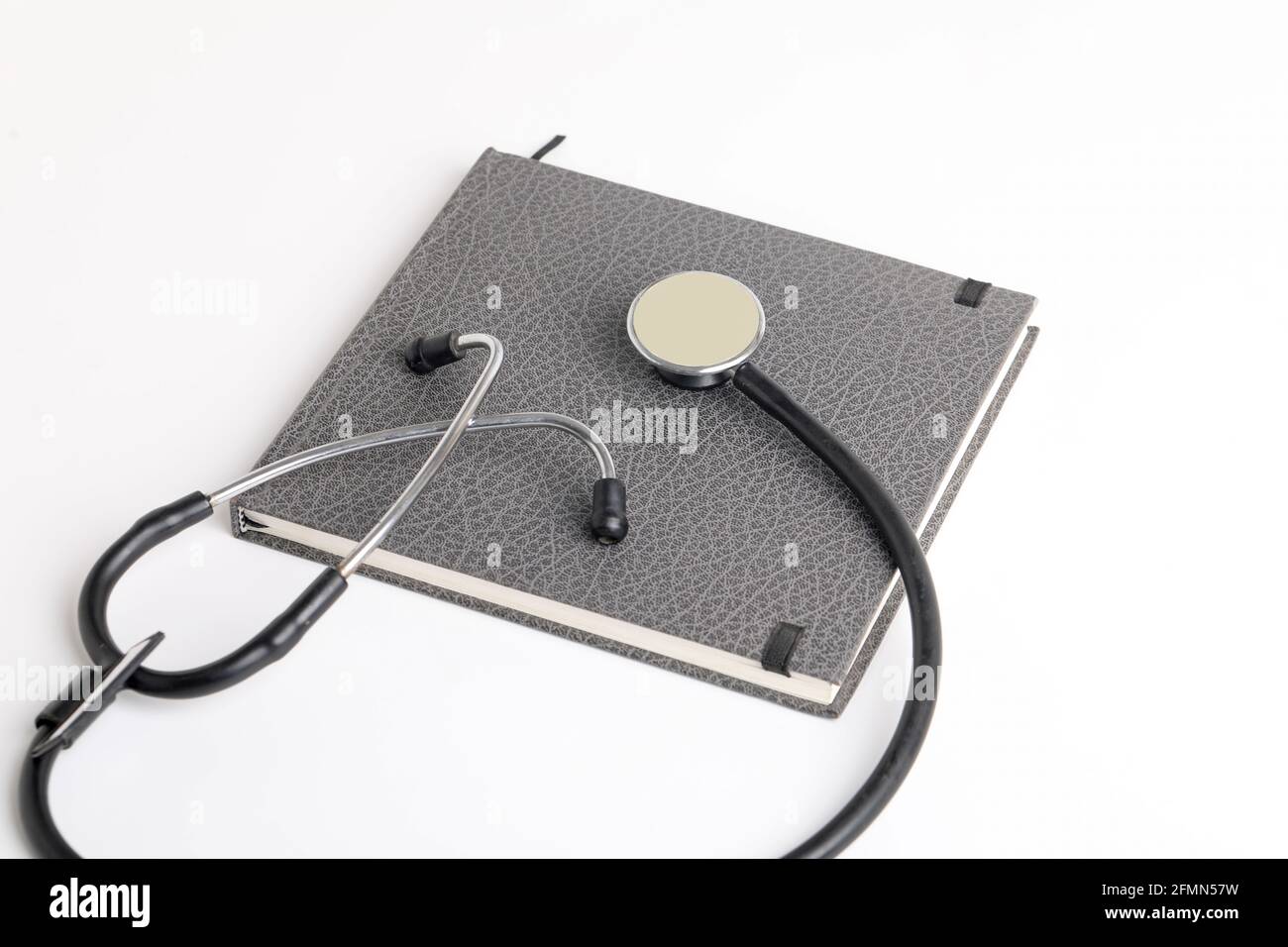Stetoscopio nero che giace sul diario, medicina. Foto Stock