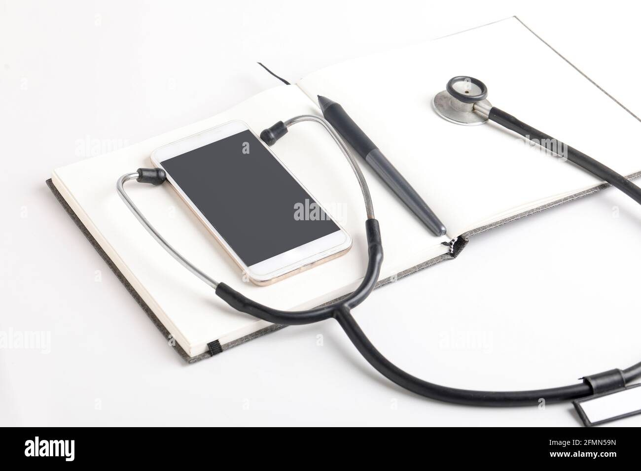 Stetoscopio nero che giace sul diario, medicina. Foto Stock