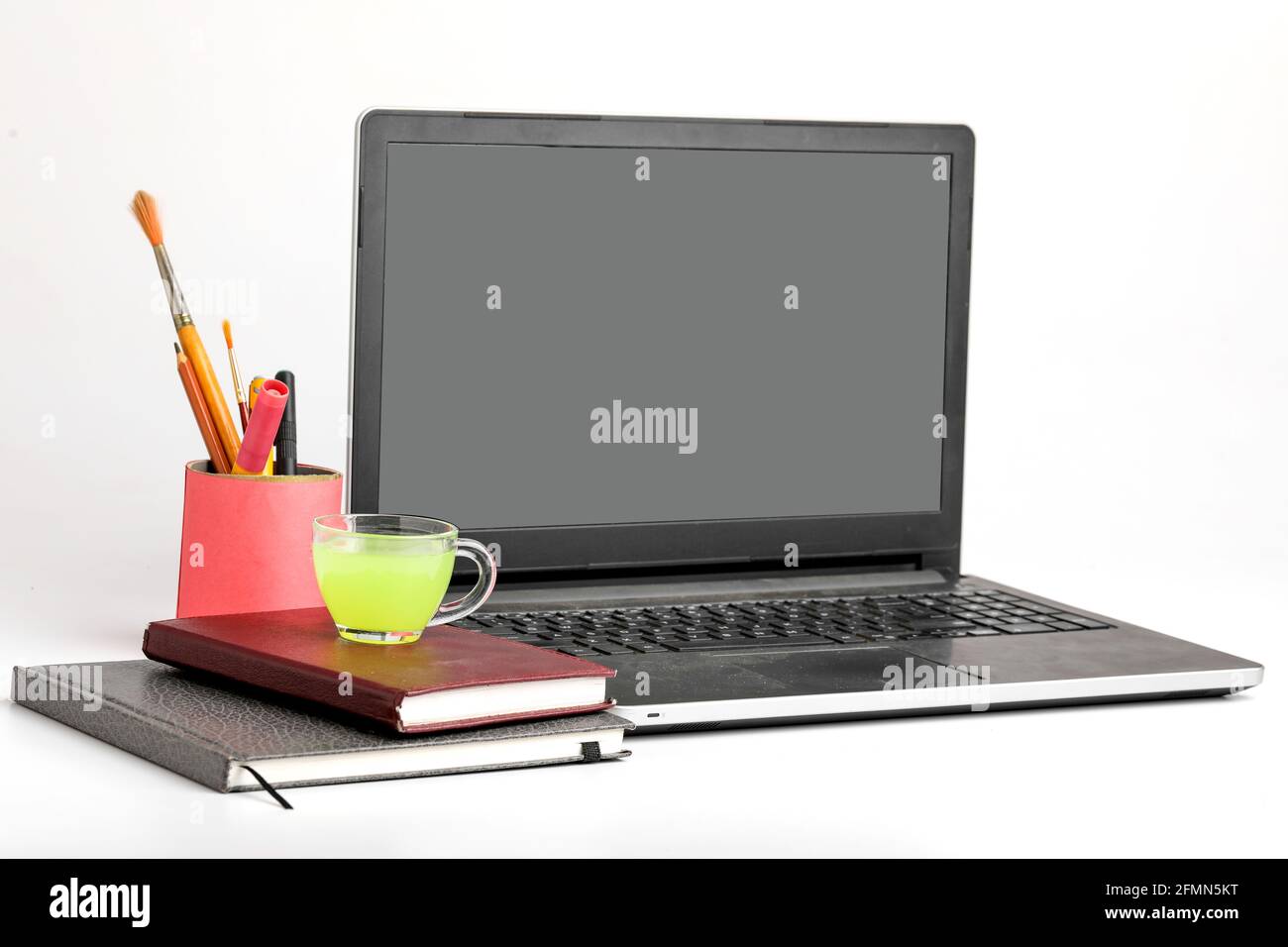 Laptop e Diario con tazza di tè verde. Concetto di lavoro da casa Foto Stock