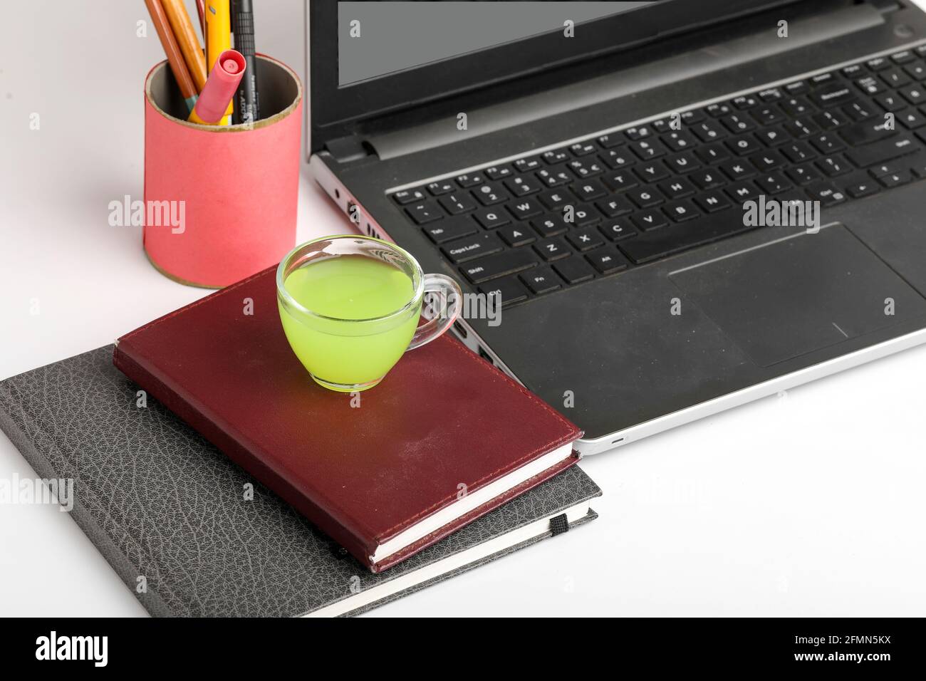 Laptop e Diario con tazza di tè verde. Concetto di lavoro da casa Foto Stock