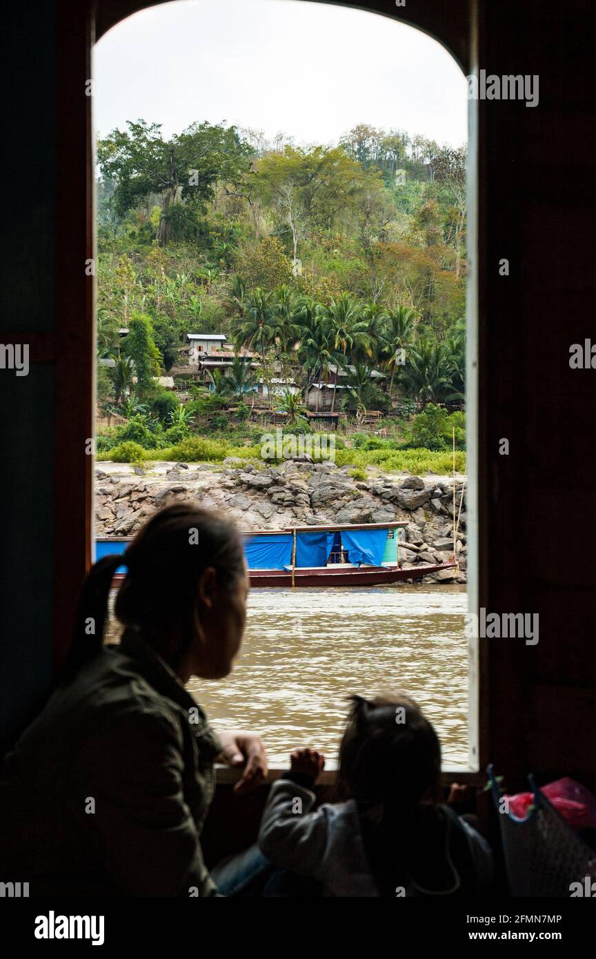 Silhouette di una donna Lao e di un bambino che guarda il paesaggio. Su una barca che salirà sul fiume Mekong da Luang Prabang a Tha Suang, Laos Foto Stock