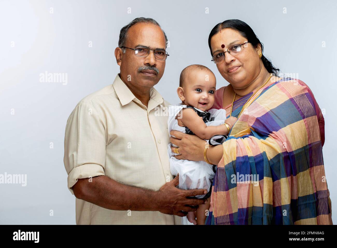 Famiglia indiana felice, grandi genitori e bambina, isolato su sfondo bianco. Foto Stock