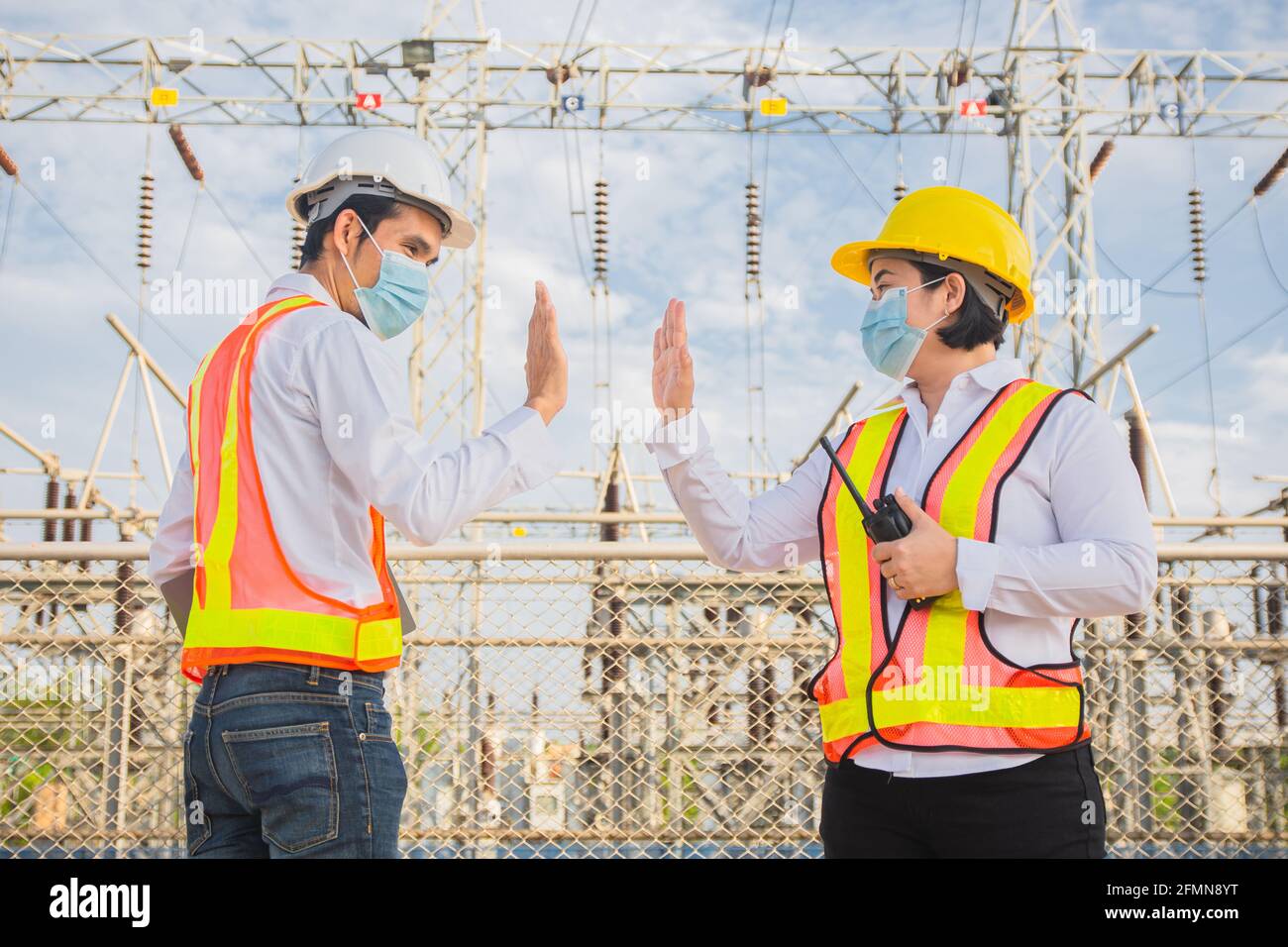 Il tecnico Teamwork agita la mano senza toccare e indossa una maschera medica proteggere il cavidio del coronavirus 19 Foto Stock