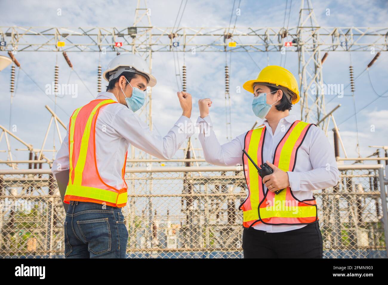 Il tecnico Teamwork agita la mano senza toccare e indossa una maschera medica proteggere il cavidio del coronavirus 19 Foto Stock