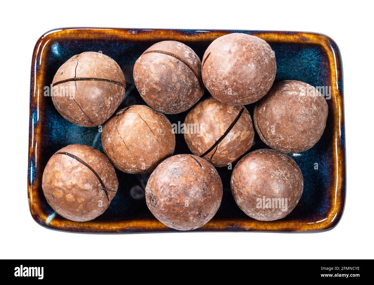 vista dall'alto di noci di macadamia cucite nella tazza ritagliata sfondo bianco Foto Stock