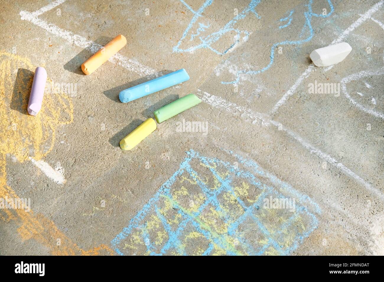 Pastelli di viola, blu, verde, giallo, bianco sul marciapiede. Dipinte con piastrelle colorate per pavimenti in pastelli. Concetto di svago per bambini. Foto Stock