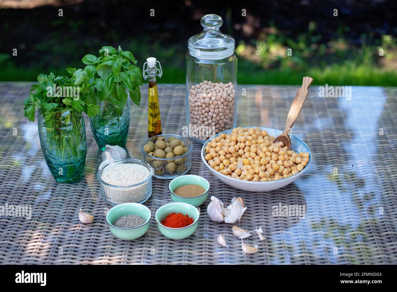 Un set di ingredienti per la preparazione di spuntini hummus: Ceci, tahini, spezie, aglio, prezzemolo, olio d'oliva . Ricetta per un Mediterraneo vegetariano Foto Stock