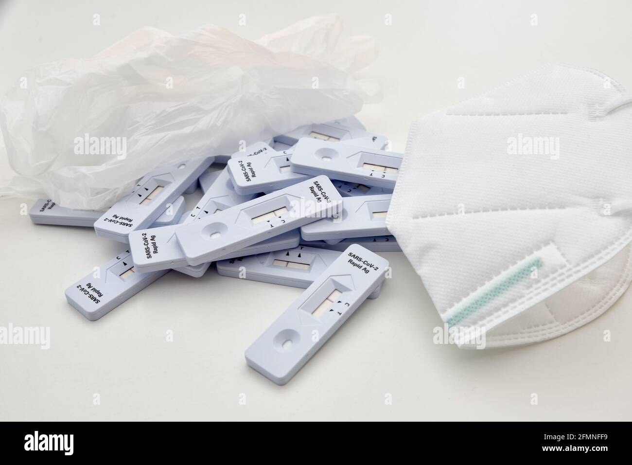 mazzo di kit di test antigene rapido del virus della coronia posati sulla superficie del laboratorio, con guanti e maschera protettiva per il viso, in quanto il medico ha bisogno di una rottura. clos Foto Stock
