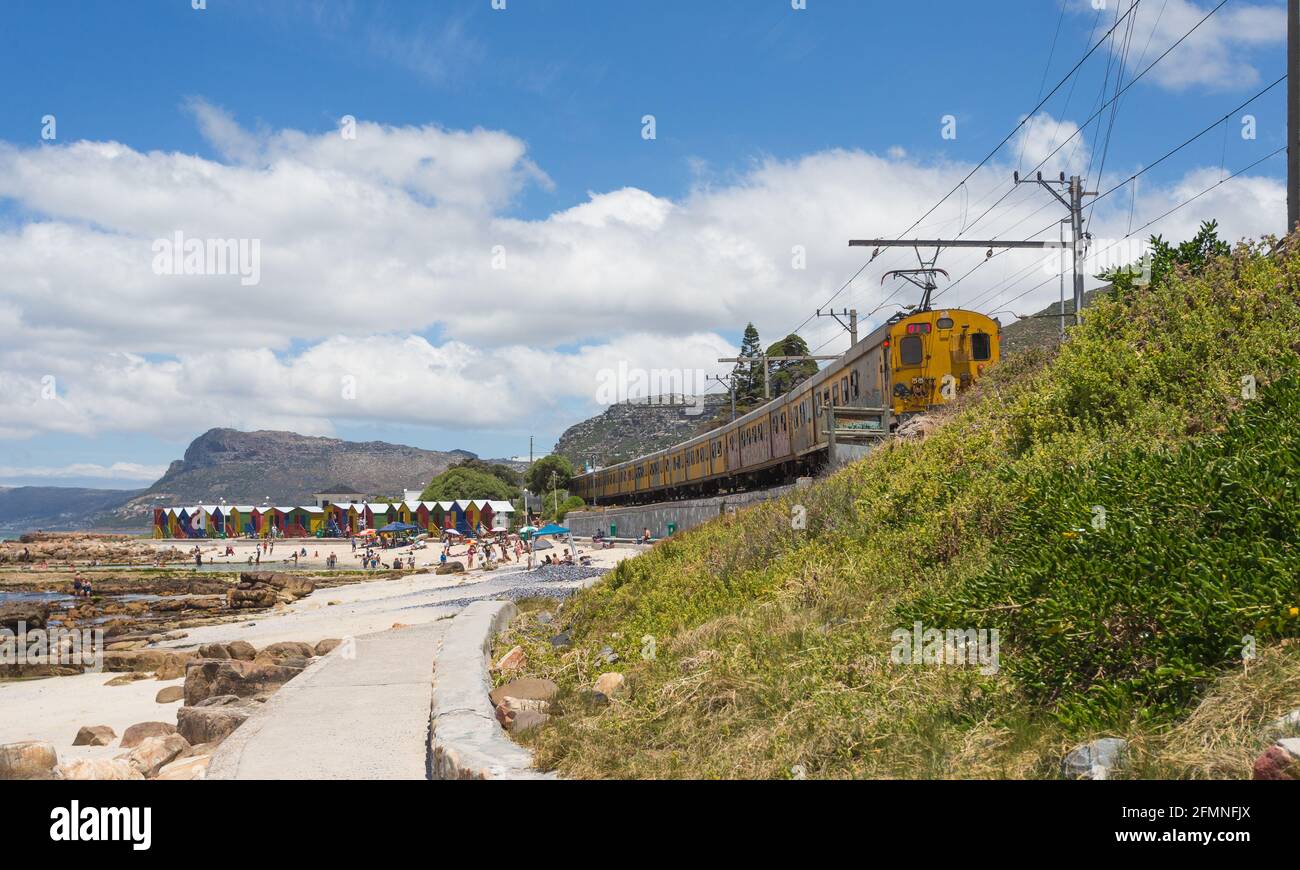 Linea ferroviaria e ferroviaria sudafricana sulla costa passando per la spiaggia di St James nel Capo Occidentale, Sud Africa Foto Stock