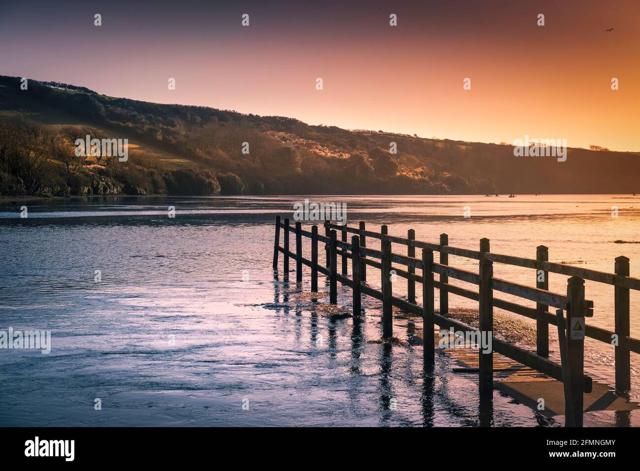 Luce serale dorata sul fiume Gannel in alta marea a Newquay in Cornovaglia. Foto Stock