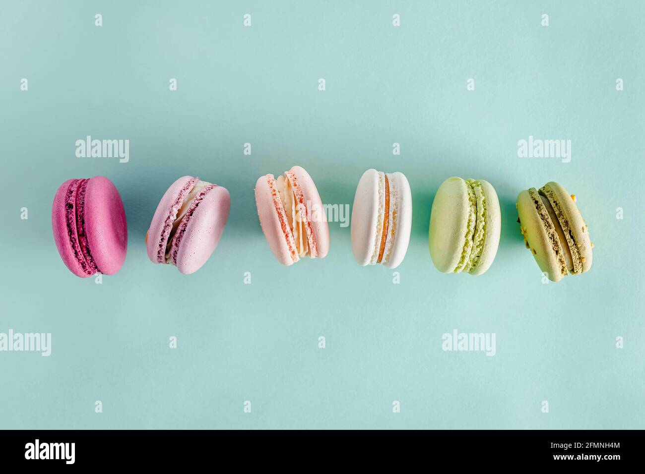 Colorati macaron da dessert su sfondo verde pastello Foto Stock