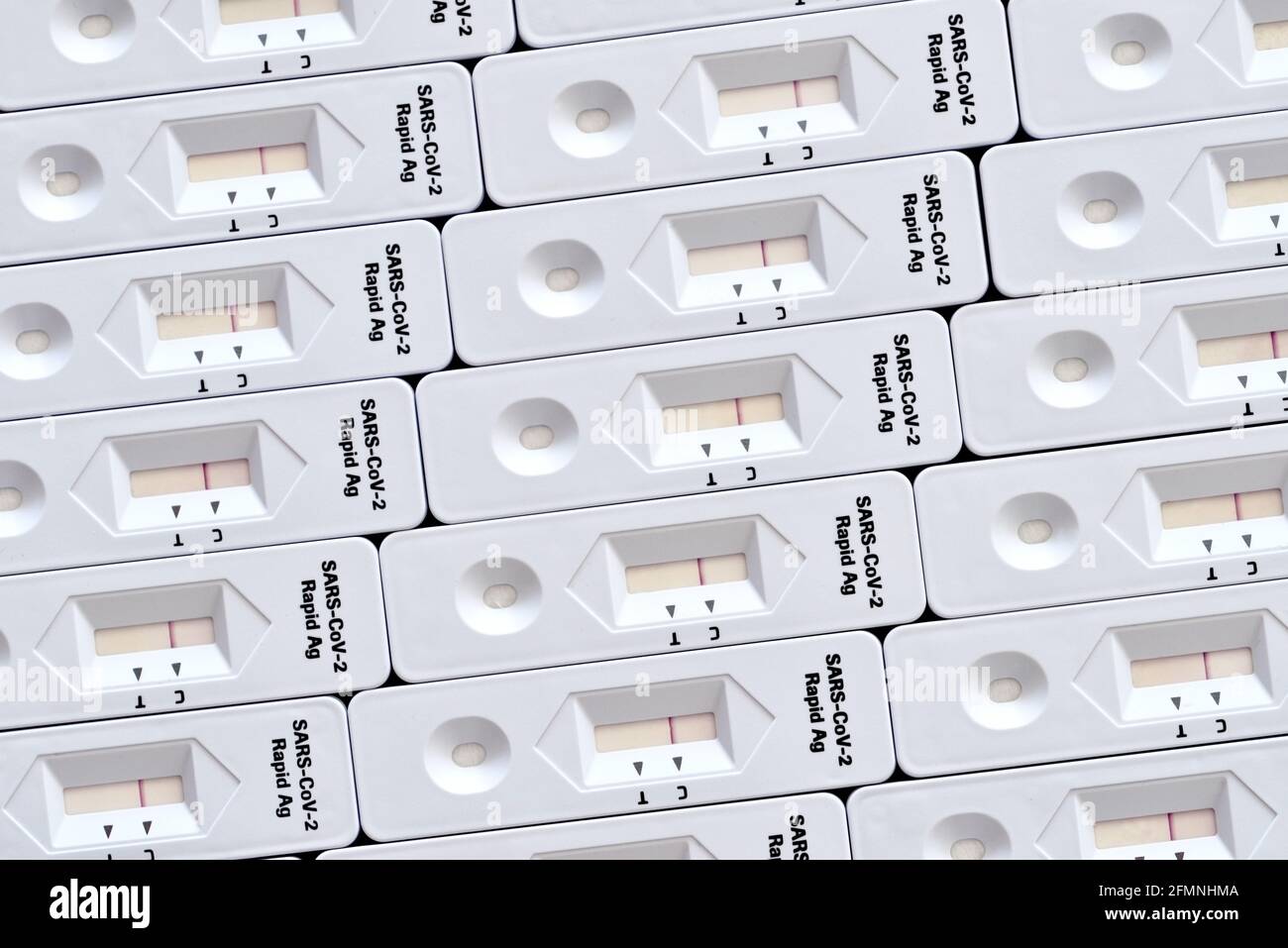 Corona Rapid Antigen test kit mosaico superficie bianca macro primo piano dettagli realizzati con molti kit di test Foto Stock