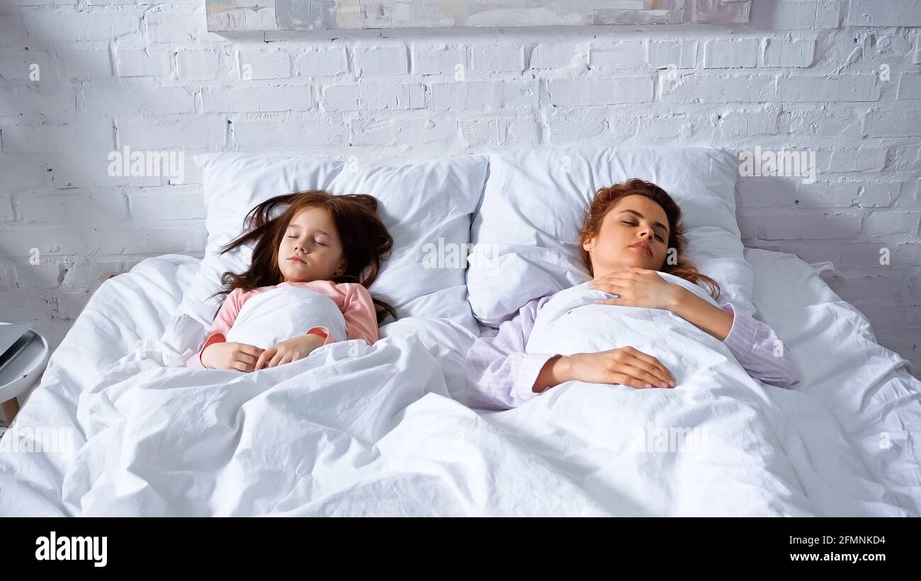 Madre e figlia dormono su lenzuola bianche la mattina Foto stock - Alamy