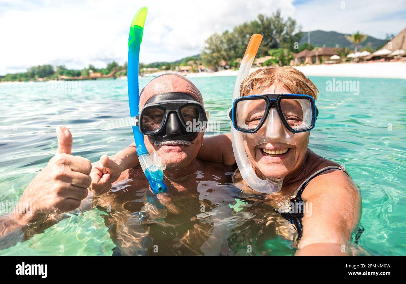 Coppia felice anziana che prende selfie in escursione tropicale del mare con Macchina fotografica - gita in barca snorkeling in scenari esotici - Anziani in pensione attivi Foto Stock