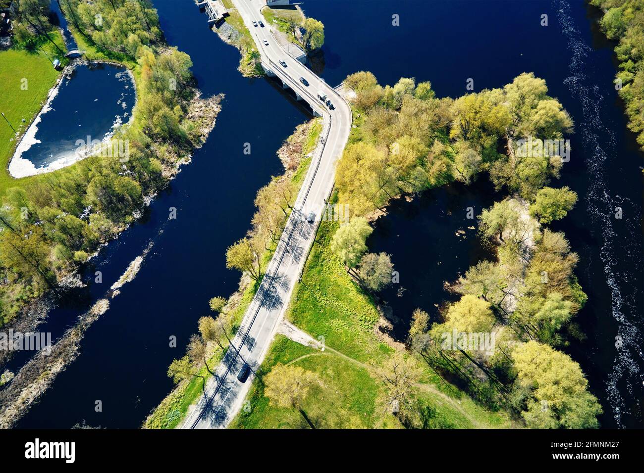 Auto che si muove sul ponte sul fiume nella città europea, vista aerea. Vista dall'alto del paesaggio della piccola città Foto Stock