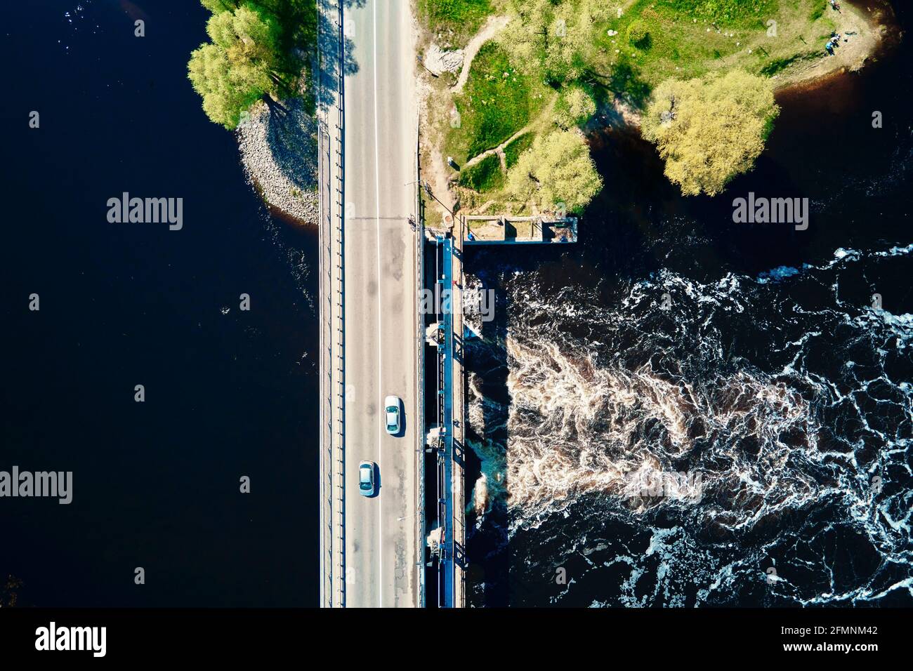 Auto che si muove sul ponte sul fiume nella città europea, vista aerea. Vista dall'alto del paesaggio della piccola città Foto Stock