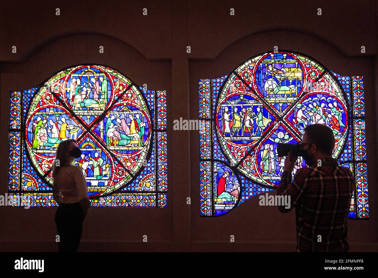 Un fotografo scatta una foto di un membro dello staff del British Museum di Londra guardando un'intera vetrata di 800 anni fa in prestito dalla cattedrale di Canterbury al museo per un nuovo 'Thomas Becket: L'assassinio e la realizzazione di un santo 'mostra che si svolge dal 20 maggio al 22 agosto 2021, come il museo si prepara per il pubblico in vista di ulteriore allentamento delle restrizioni di blocco in Inghilterra. Data immagine: Martedì 11 maggio 2021. Foto Stock