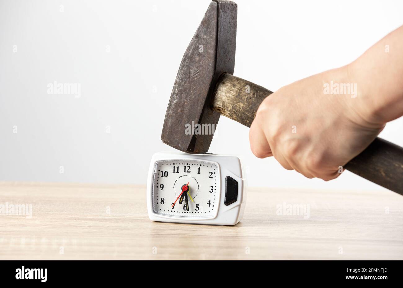 Vista ravvicinata del martello e della sveglia. Gestione della rabbia e hating concetto di mattina. Foto Stock