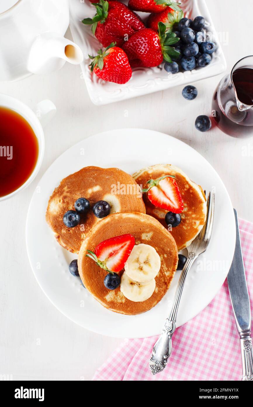 Frittelle americane classiche fatte in casa con frutti di bosco freschi e sciroppo, vista dall'alto Foto Stock
