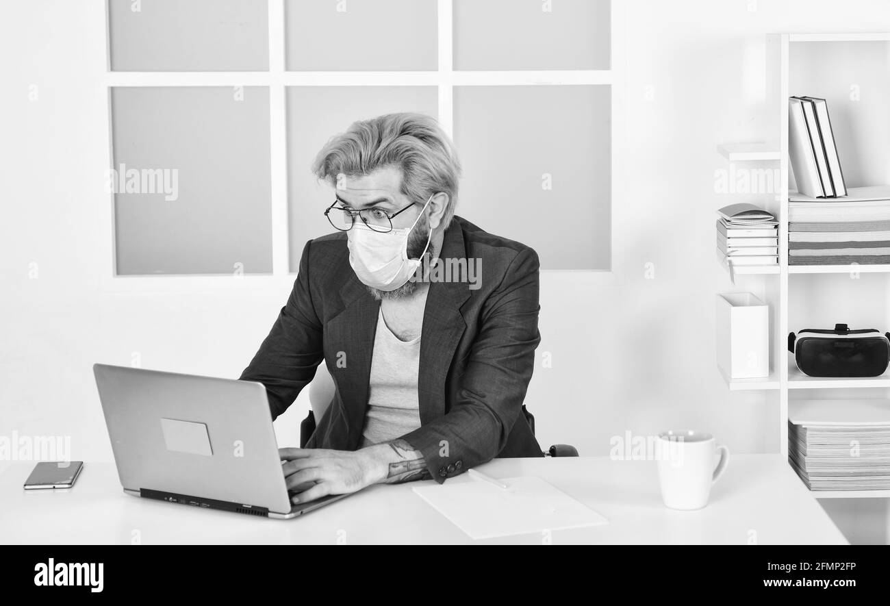 Rimani a casa. Lavorare da casa. Online. Tattica di auto-isolamento top Response per la gestione dello scoppio di COVID 19. Ufficio domestico. Uomo indossare maschera medica lavoro Foto Stock