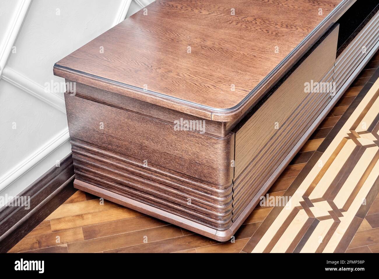 Elegante commode per set TV realizzato in impiallacciatura e solido legname di quercia di colore marrone scuro su blocco di legno piano di pavimento in parquet Foto Stock