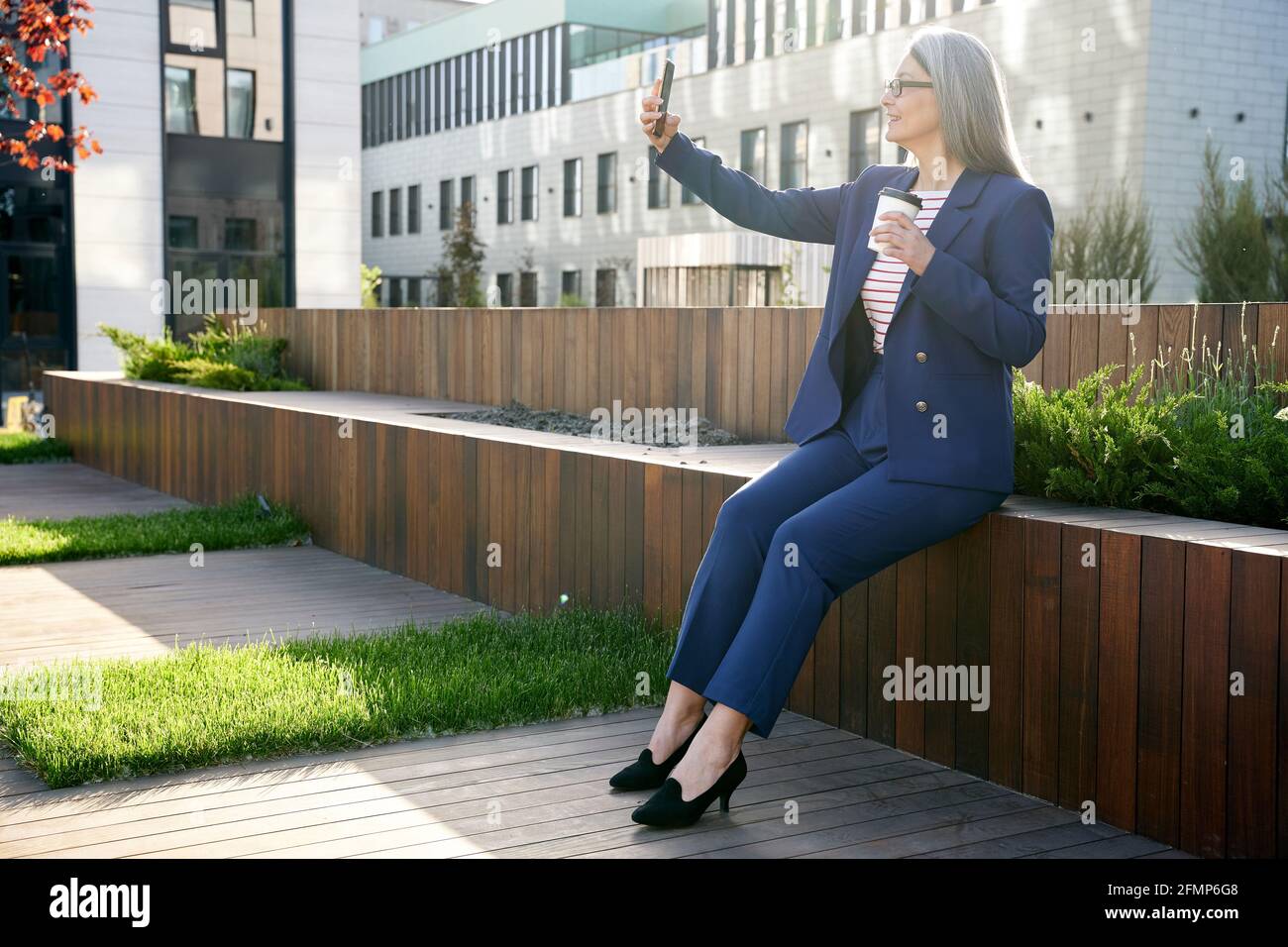 Business-lady di successo che scatta una foto di se stessa in un vestito di fantasia Foto Stock