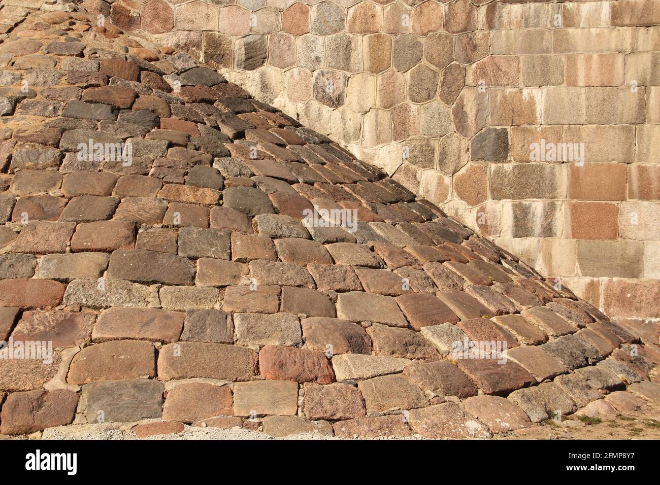 Antico colore pastello pietre di dimensioni casuali e mattoni muro e. bastione Foto Stock