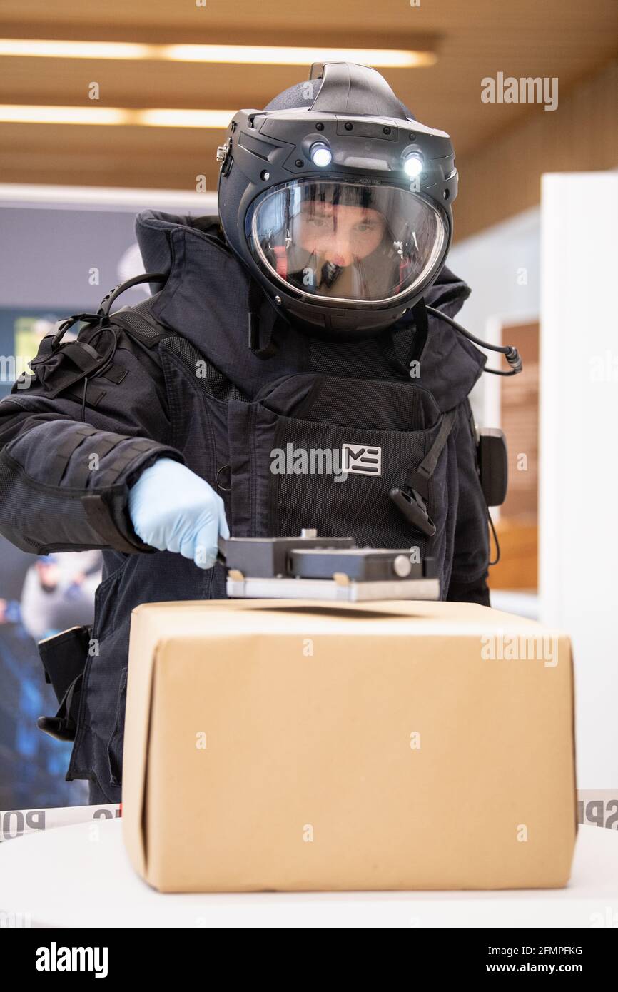 Monaco, Germania. 11 Maggio 2021. Un membro del gruppo tecnico speciale (TSG) dell'Ufficio di polizia penale dello Stato bavarese (LKA) in una tuta bomba cerca un pacchetto con un rivelatore di radiazioni alfa, beta, gamma durante una conferenza stampa in occasione del 75° anniversario dell'Ufficio di polizia penale dello Stato in Baviera. Credit: Attias Balk/dpa/Alamy Live News Foto Stock