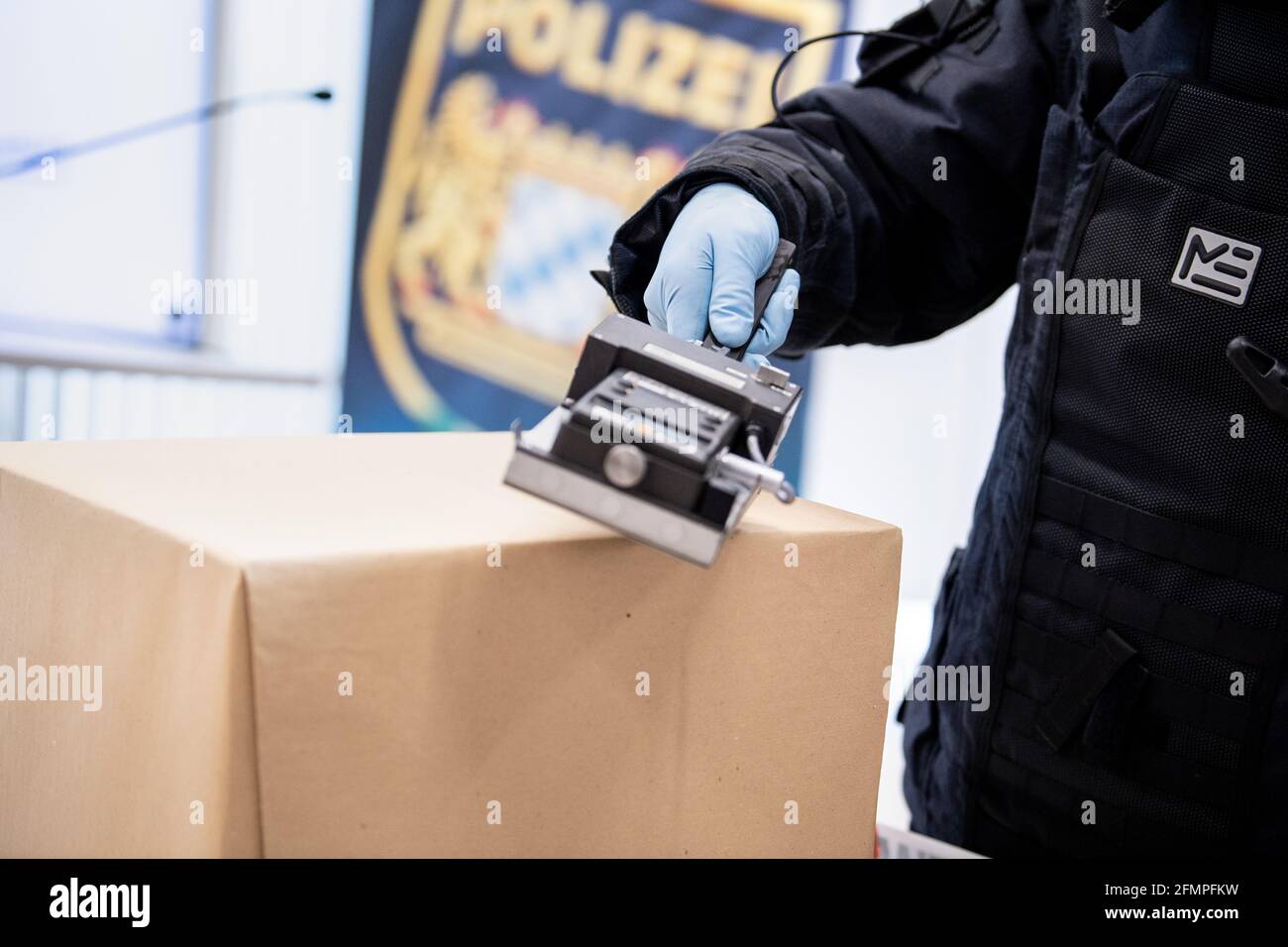 Monaco, Germania. 11 Maggio 2021. Un membro del gruppo tecnico speciale (TSG) dell'Ufficio di polizia penale dello Stato bavarese (LKA) in una tuta bomba cerca un pacchetto con un rivelatore di radiazioni alfa, beta, gamma durante una conferenza stampa in occasione del 75° anniversario dell'Ufficio di polizia penale dello Stato in Baviera. Credit: Attias Balk/dpa/Alamy Live News Foto Stock