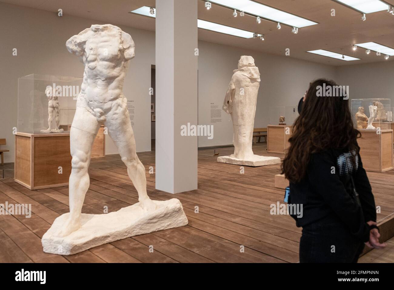 Londra, Regno Unito. 11 maggio 2021. Un membro dello staff si pone con 'The Walking Man, Large Version', 1908, di Auguste Rodin. Anteprima a Tate Modern di "la realizzazione di Rodin", una nuova grande mostra di oltre 200 opere scultoree di Auguste Rodin, molte delle quali non sono mai state mostrate fuori dalla Francia. La mostra segna la riapertura del museo, in quanto il governo britannico facilita alcune restrizioni di blocco del coronavirus ed è aperta dal 18 maggio al 21 novembre. Credit: Stephen Chung / Alamy Live News Foto Stock